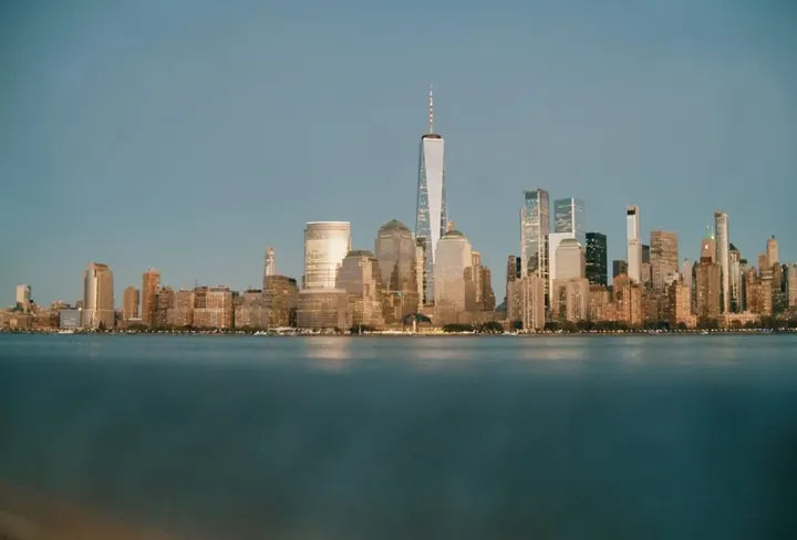 LUMIX G 20/F1.7 II · 19mm · ISO 4289 · 1/50s · f/4 Lower Manhattan skyline at dusk across the Hudson, shot at ISO 4289, captured with Caira
