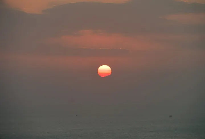 LUMIX G VARIO 14-140/F3.5-5.6 · 135mm · ISO 951 · 1/1910s · f/8.0 Sun setting over open sea, captured with Caira