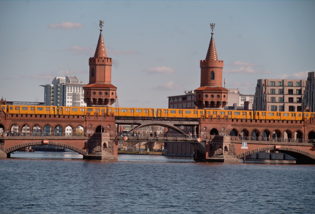 Yellow U-Bahn train crossing Berlin's Oberbaum Bridge — captured with Caira