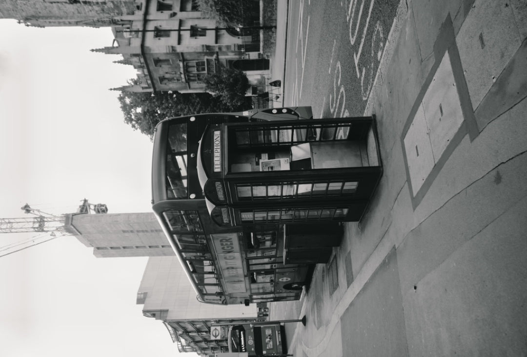 Black-and-white London street scene with a telephone box and double-decker bus — captured with Caira