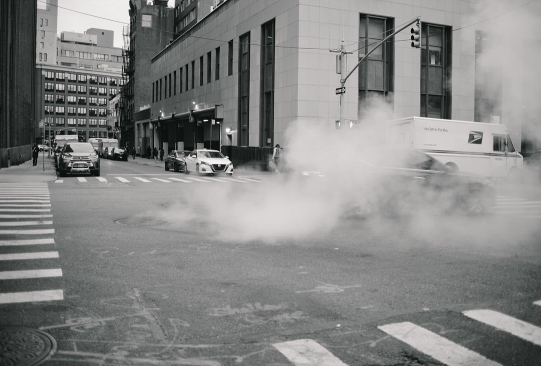 Steam drifting across a black-and-white New York intersection — captured with Caira