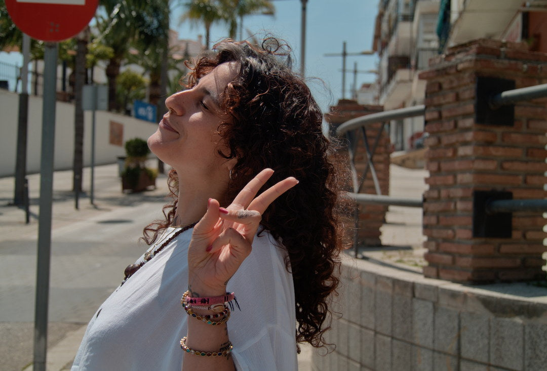 Woman laughing on a sunlit village street, captured with Caira