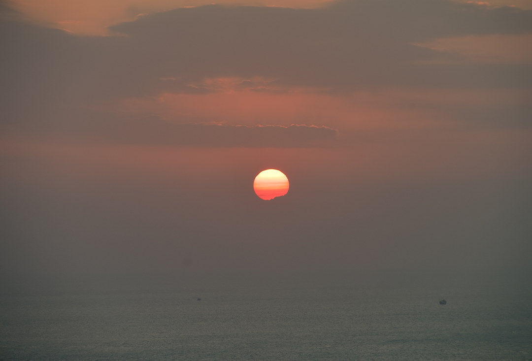 Sun setting over open sea, captured with Caira