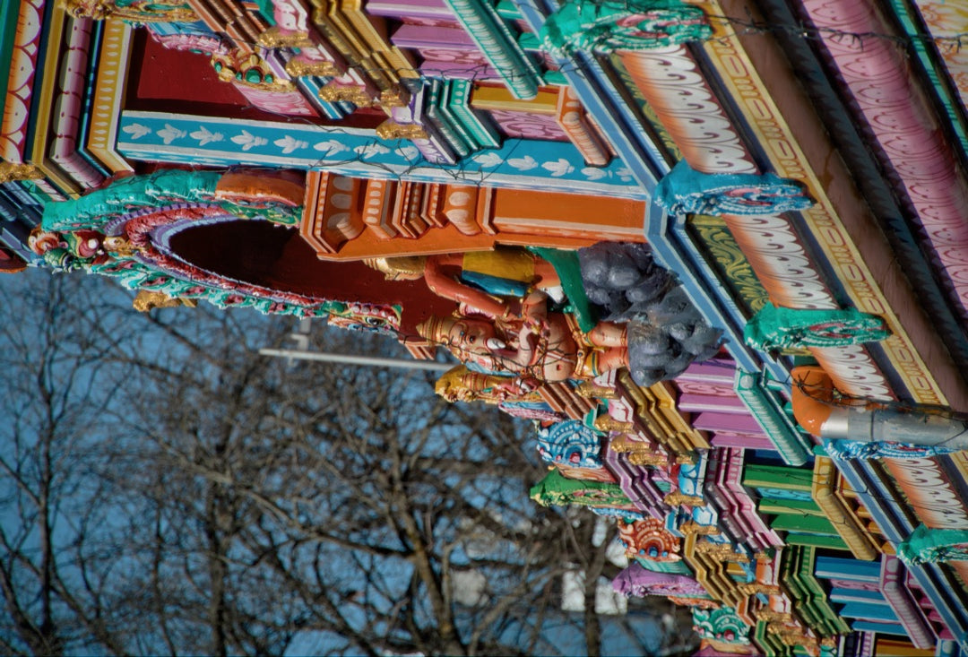 Brightly painted figures on a Hindu temple facade — captured with Caira