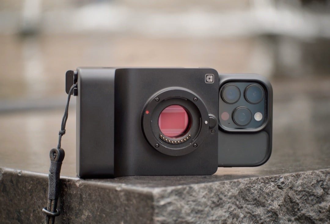 Black Caira with open Micro Four Thirds mount clipped to an iPhone