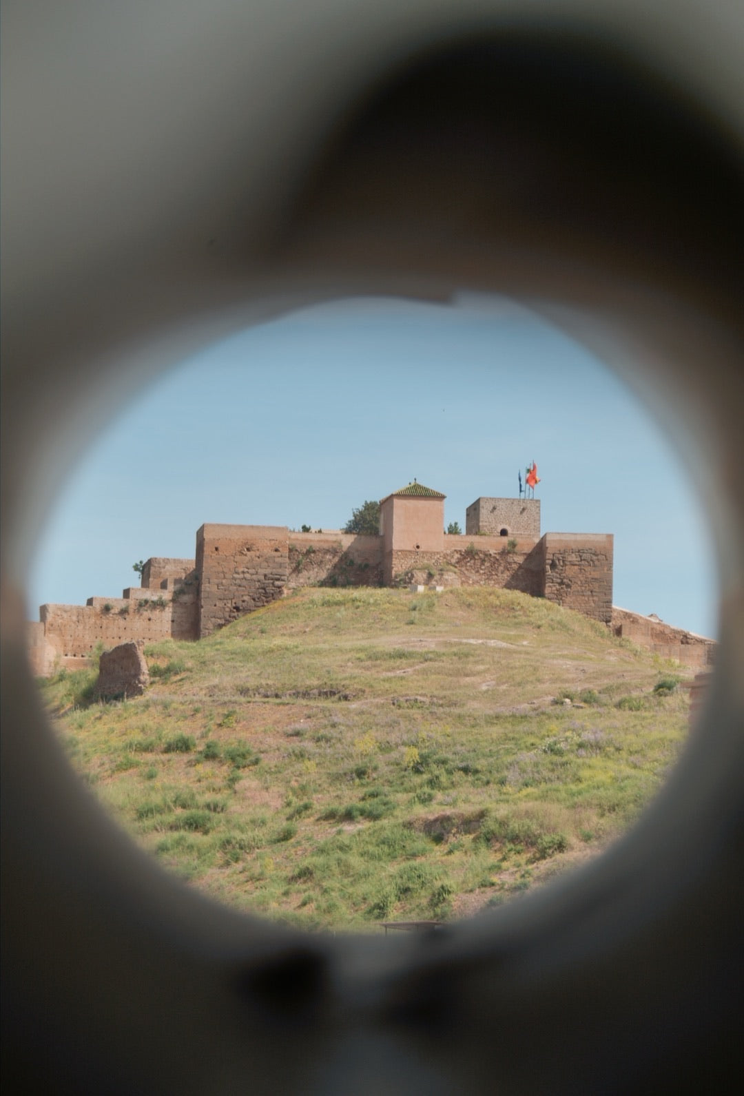 Hilltop castle framed through a circular viewing scope