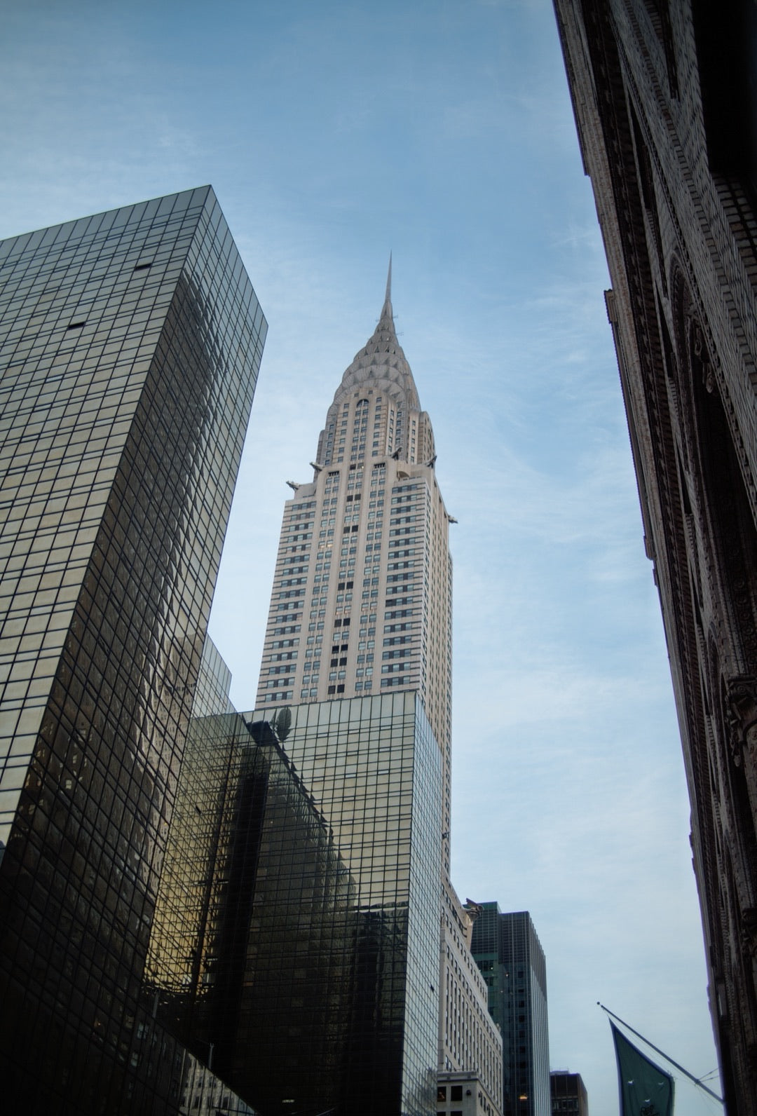 Chrysler Building framed by glass towers, looking up
