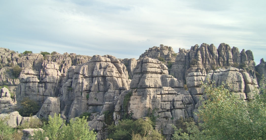 Layered limestone rock formations under a soft sky