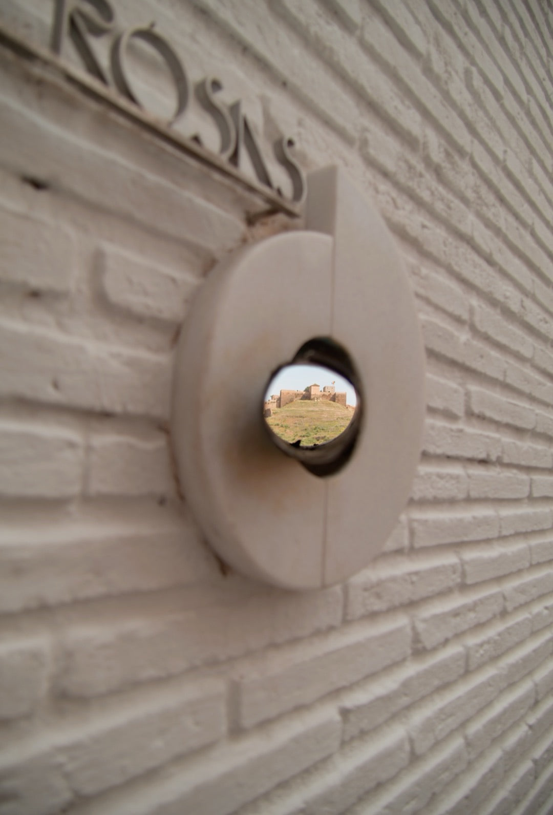 Mirrored sphere set in a sculpted brick wall