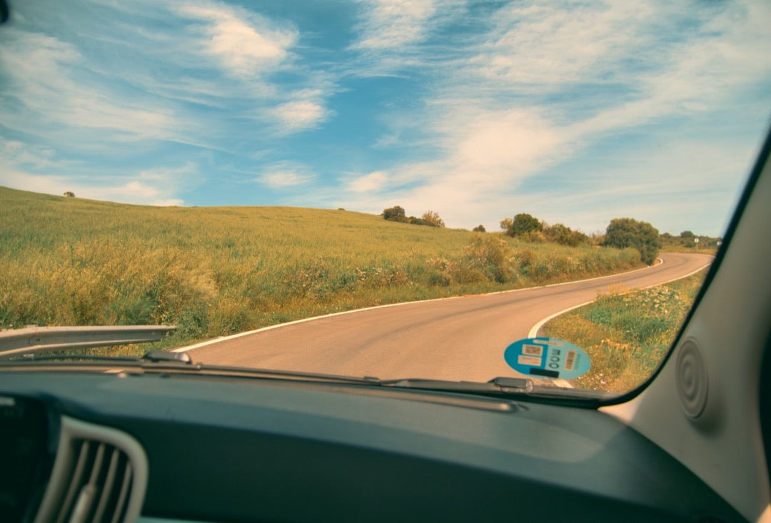 Open country road through the windscreen of a Fiat 500