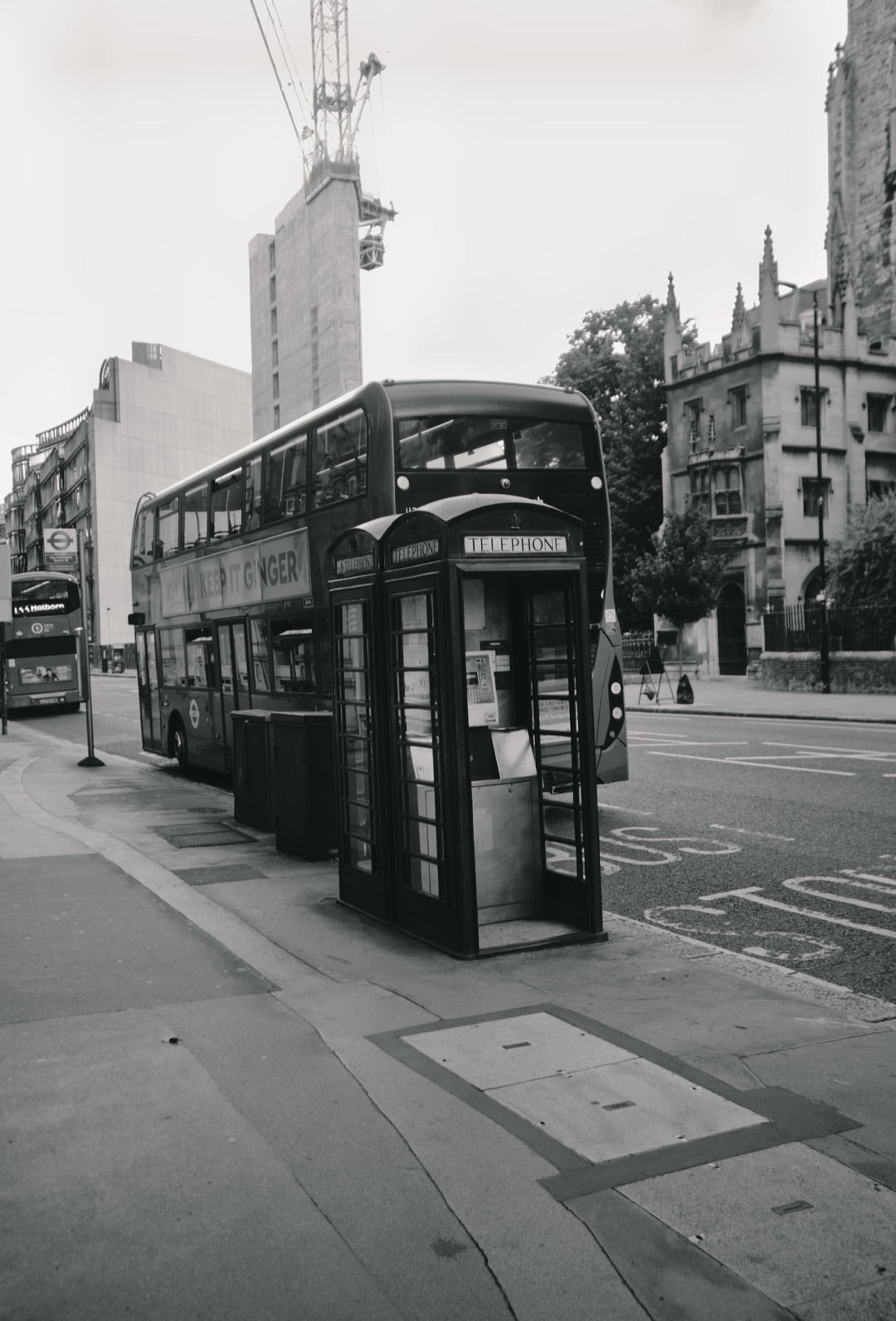 Black-and-white London street scene with a telephone box and double-decker bus