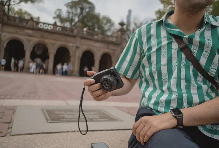 Man in a striped shirt with Caira on a wrist strap, Bethesda Terrace
