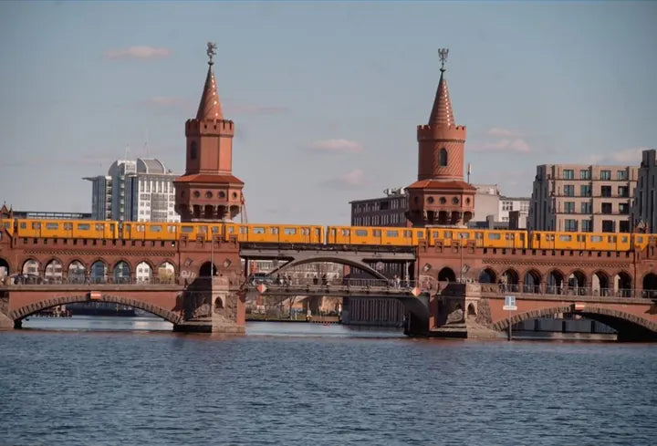Yellow U-Bahn train crossing Berlin's Oberbaum Bridge, captured with Caira