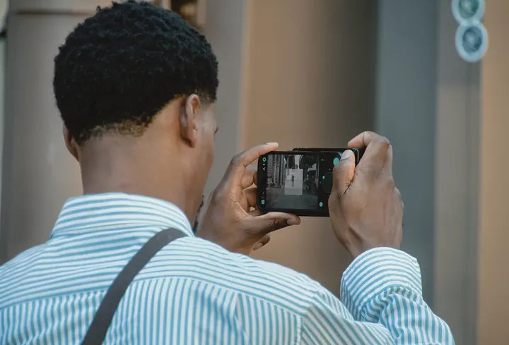 Creator framing a shot with Caira, iPhone screen in view