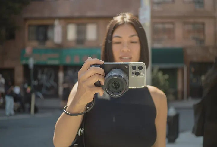 Woman framing a shot with Caira at eye level · camera whole